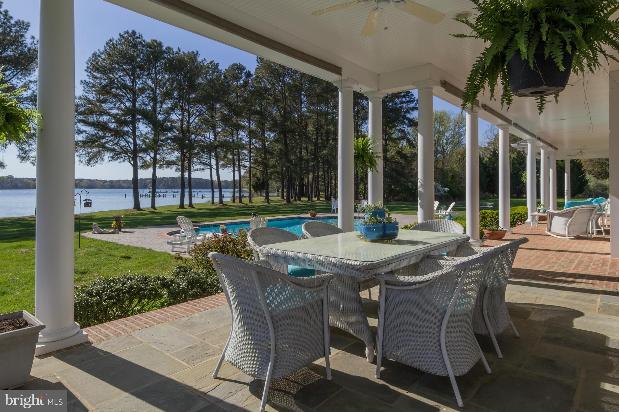 8092 Church Neck Road St. Michaels, MD 21663 - Photo 21 of 27 a view of a patio with a table chairs and a backyard