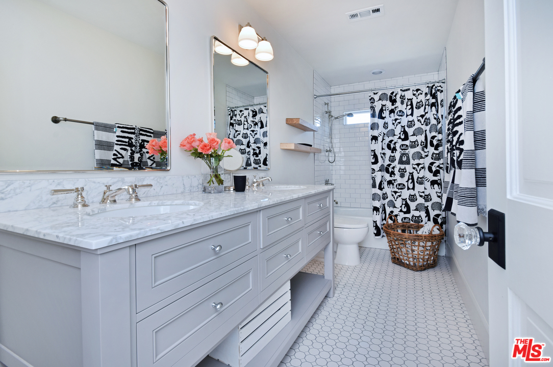 560 Cold Canyon Road Calabasas, CA 91302 - Photo 27 of 38 a bathroom with a granite countertop sink a large mirror and a shower