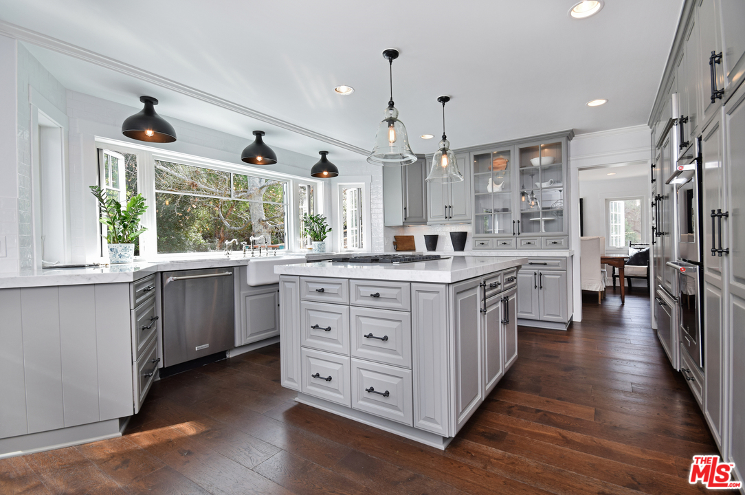 560 Cold Canyon Road Calabasas, CA 91302 - Photo 4 of 38 a large white kitchen with a large window a sink and stainless steel appliances