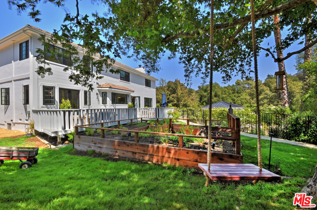 560 Cold Canyon Road Calabasas, CA 91302 - Photo 33 of 38 a view of a house with a yard table and chairs