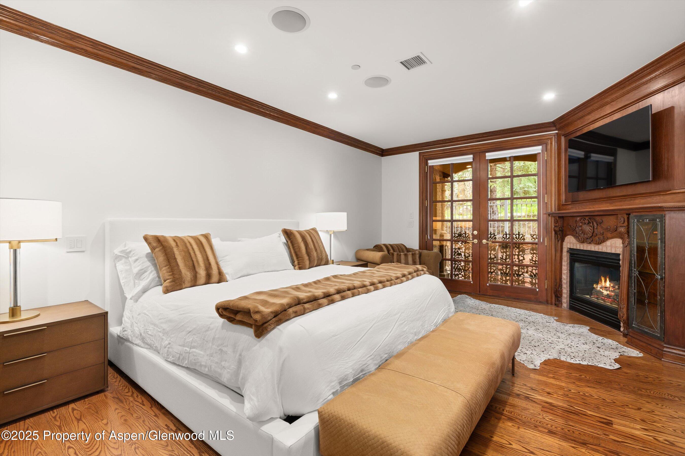 918 South Mill Street, Unit A Aspen, CO 81611 - Photo 13 of 34 a spacious bedroom with a large bed and a fireplace