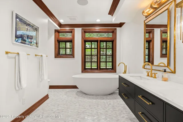 a bathroom with a bathtub double vanity sink and a window