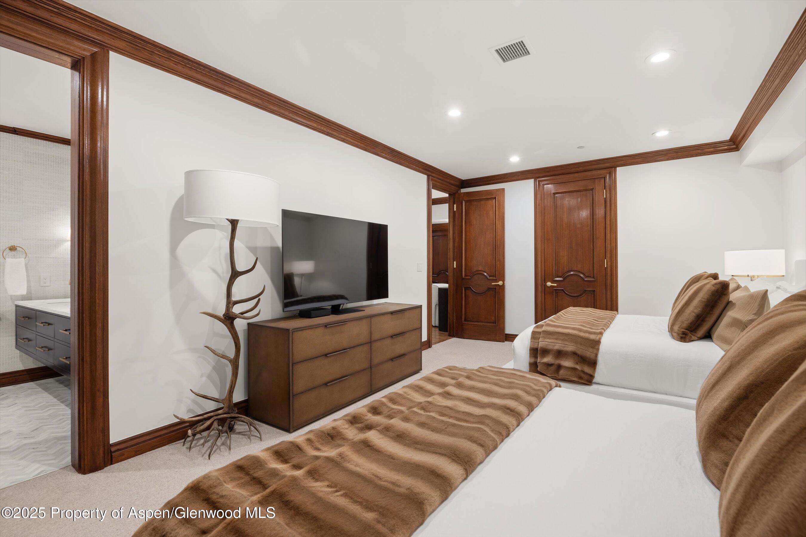 918 South Mill Street, Unit A Aspen, CO 81611 - Photo 22 of 34 a bedroom with a bed and a flat tv screen on dresser