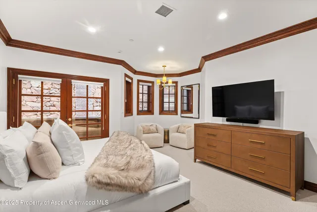 a spacious bedroom with a large bed and a flat screen tv