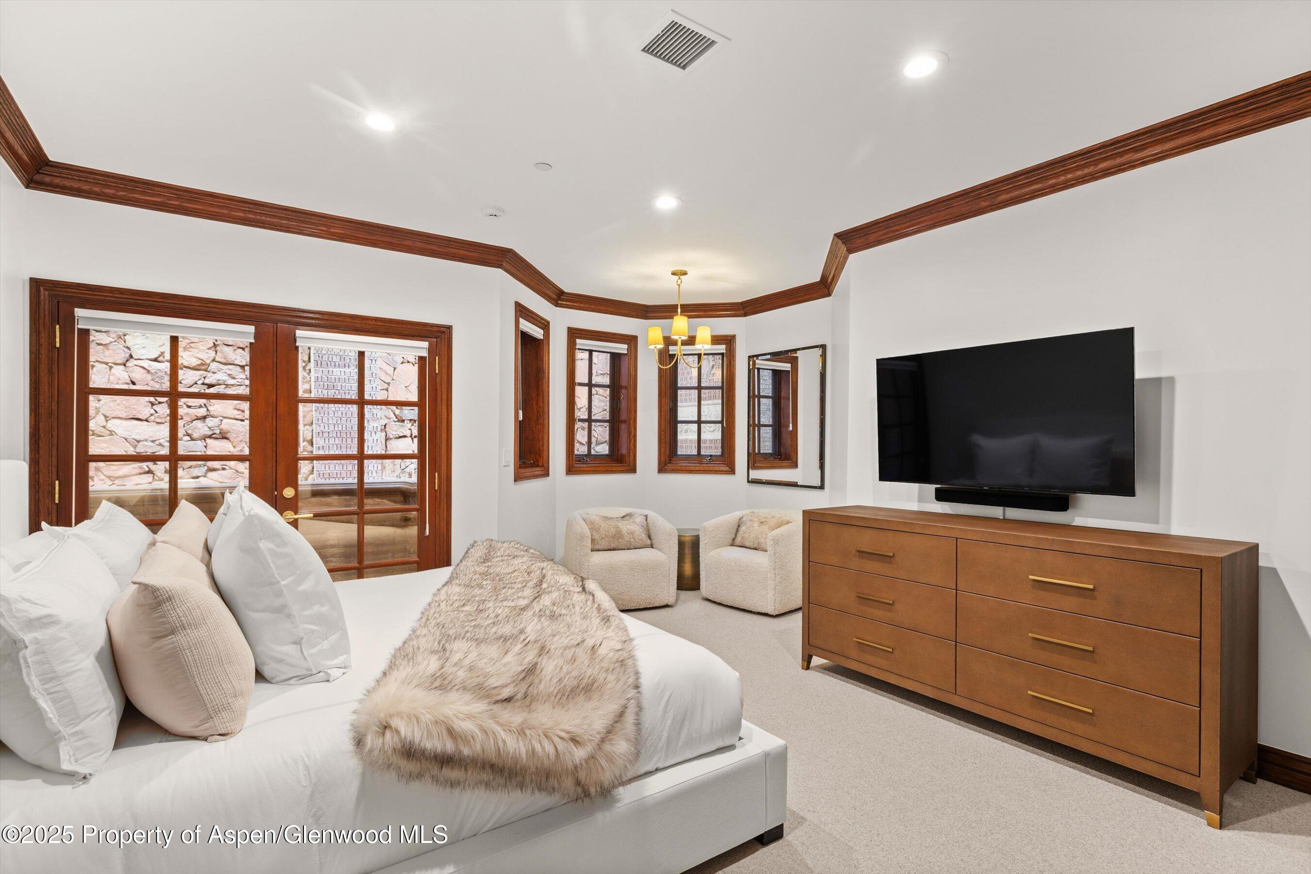 918 South Mill Street, Unit A Aspen, CO 81611 - Photo 24 of 34 a spacious bedroom with a large bed and a flat screen tv