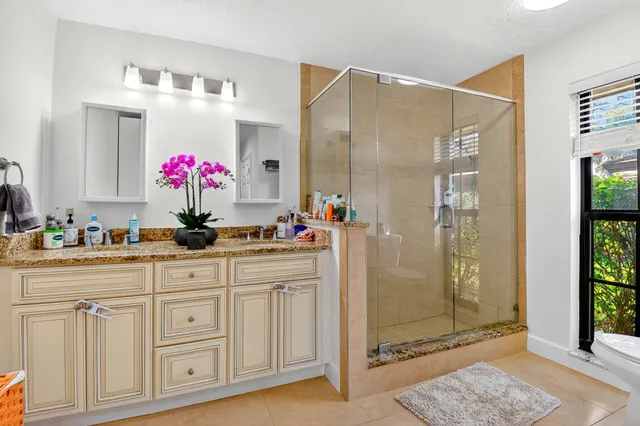 a bathroom with a shower sink and mirror