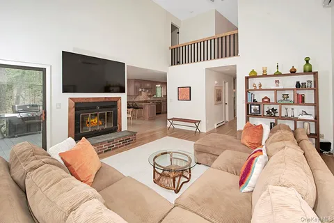 a living room with furniture a flat screen tv and a fireplace