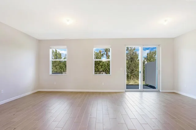 an empty room with wooden floor and window