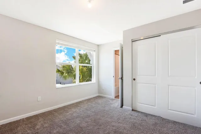 an empty room with windows and closet