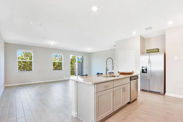 a kitchen with a sink cabinets and wooden floor