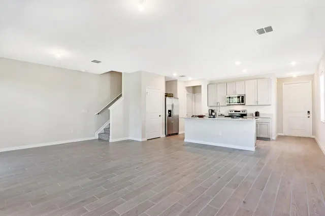 a view of a kitchen with wooden floor and electronic appliances