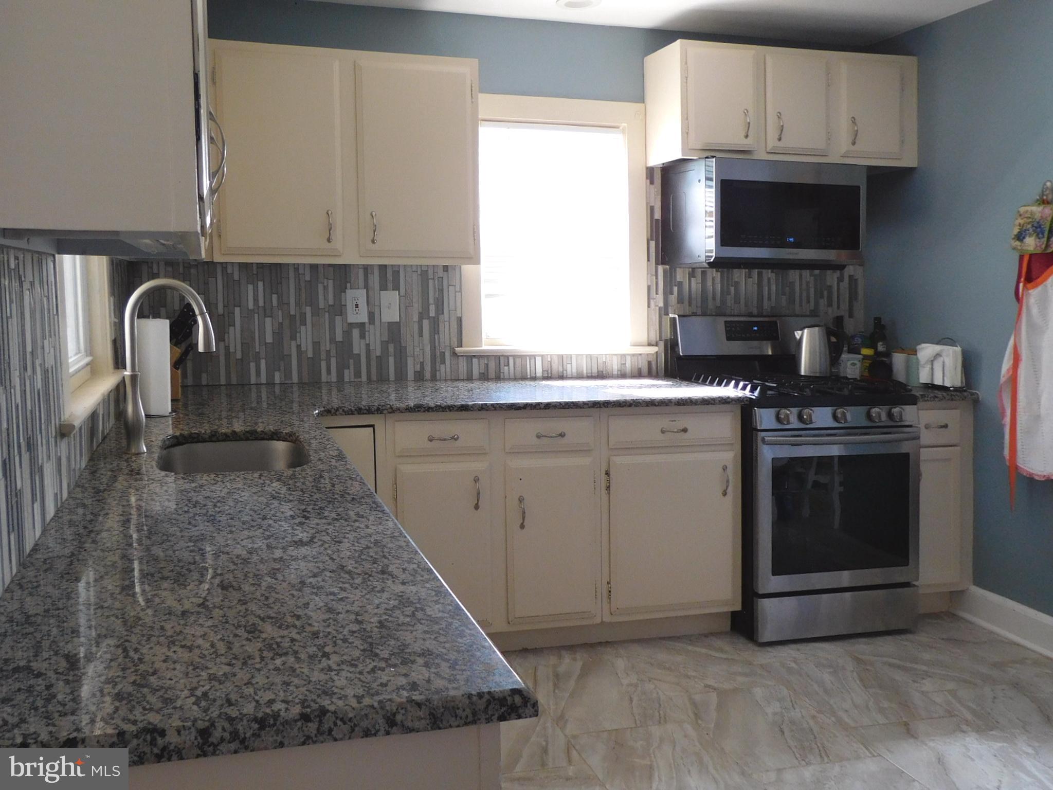 719 Hickory Street Delanco, NJ 08075 - Photo 9 of 29 a kitchen with stainless steel appliances granite countertop a stove a sink and a microwave