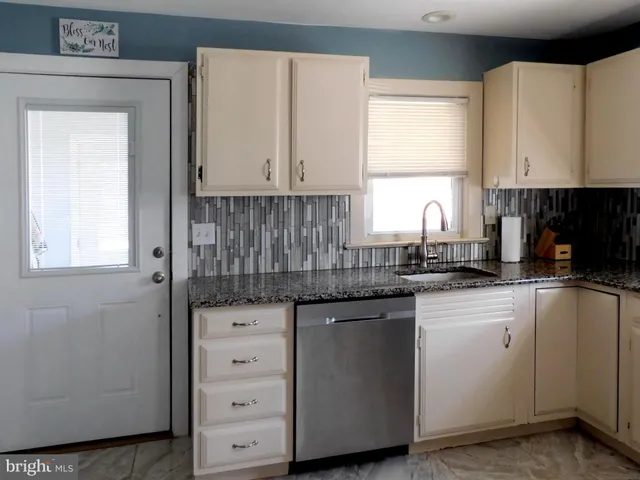 a kitchen with cabinets appliances a sink and a window