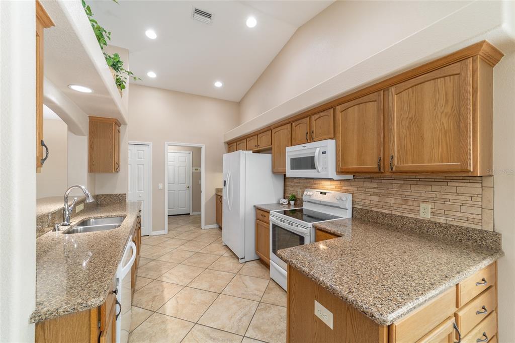 16369 Southwest 14th Avenue Road Ocala, FL 34473 - Photo 18 of 49 a kitchen with stainless steel appliances granite countertop a sink stove and refrigerator