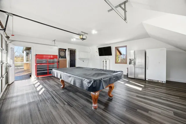 a view of a large pool with lawn chairs under an umbrella