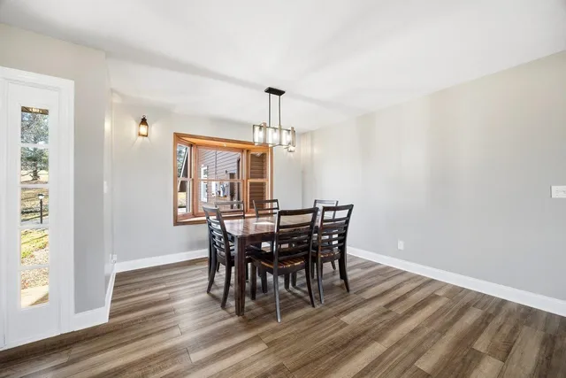 a view of a dining room with furniture wooden floor and chandelier