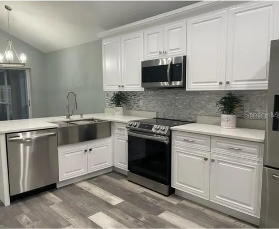 a kitchen with white cabinets and appliances
