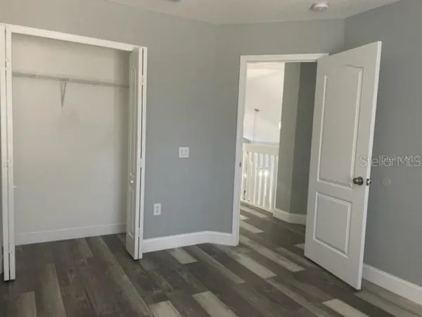 an empty room with wooden floor and a bathroom