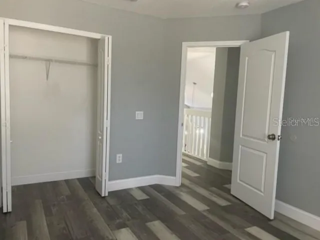 an empty room with wooden floor and a bathroom