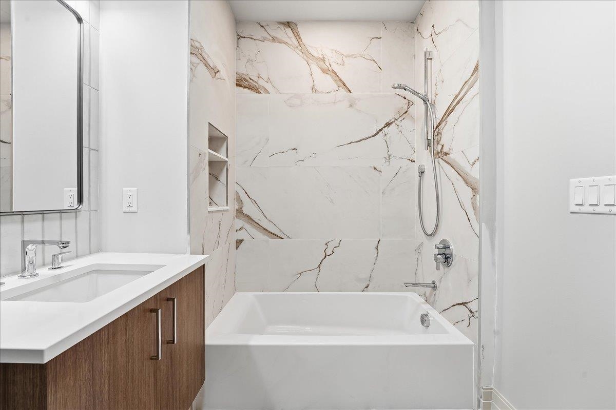 921 Madison Street, Unit 604 Hoboken, NJ 07030 - Photo 15 of 22 a bathroom with a sink a mirror and a bathtub