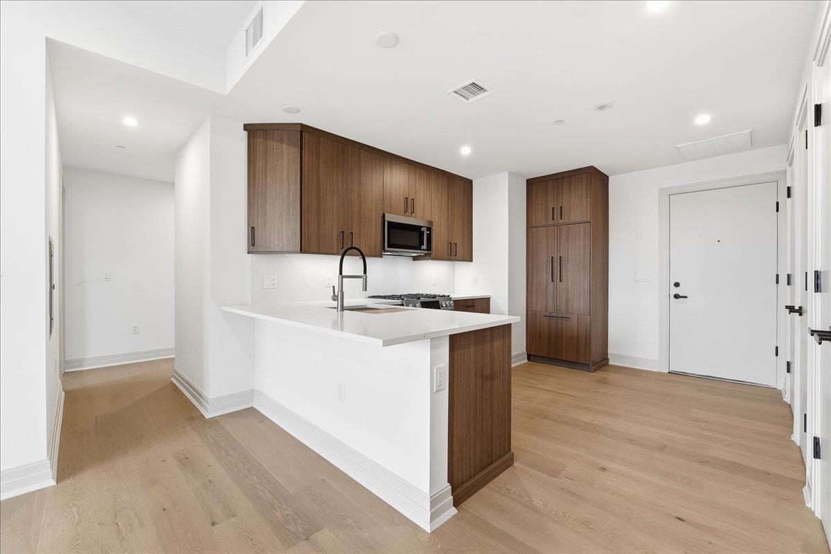 921 Madison Street, Unit 604 Hoboken, NJ 07030 - Photo 4 of 22 a kitchen with stainless steel appliances a sink stove and refrigerator
