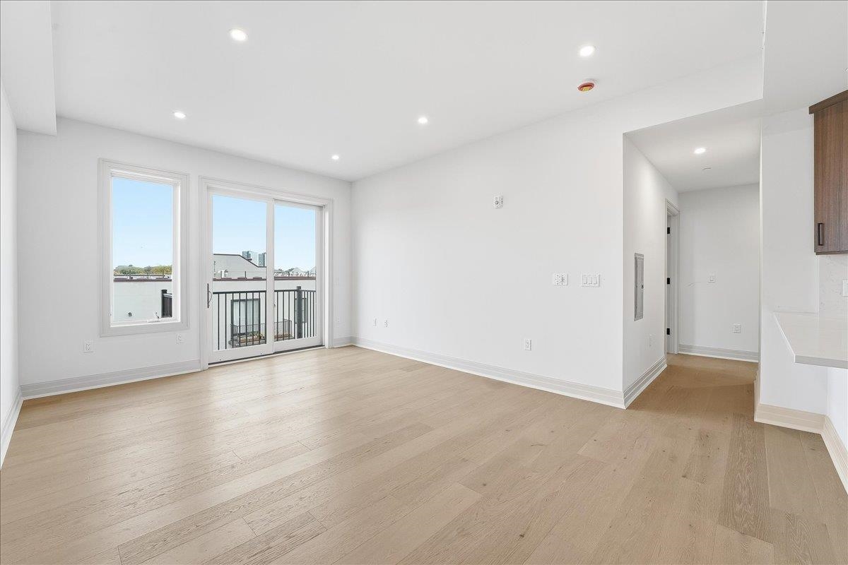 921 Madison Street, Unit 604 Hoboken, NJ 07030 - Photo 7 of 22 an empty room with wooden floor and windows