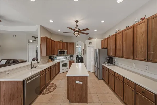 a kitchen with granite countertop a refrigerator a sink dishwasher a stove and a refrigerator