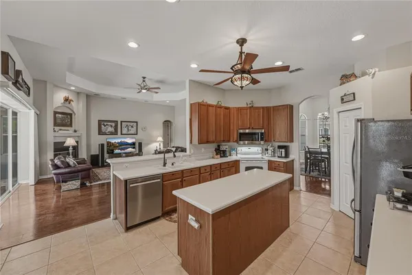 a kitchen with a refrigerator a sink and wooden cabinets
