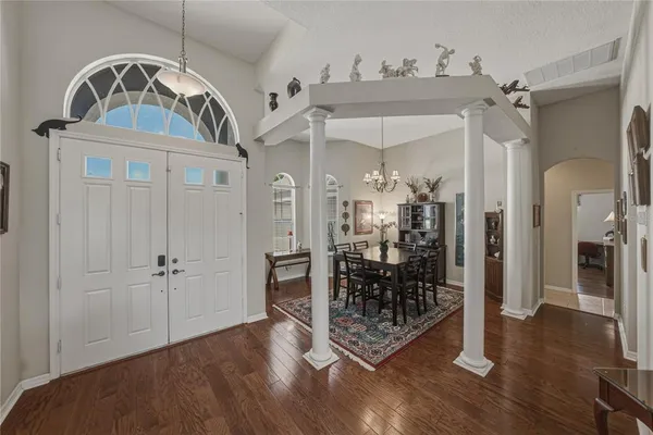 a view of a dining room with furniture a chandelier and wooden floor