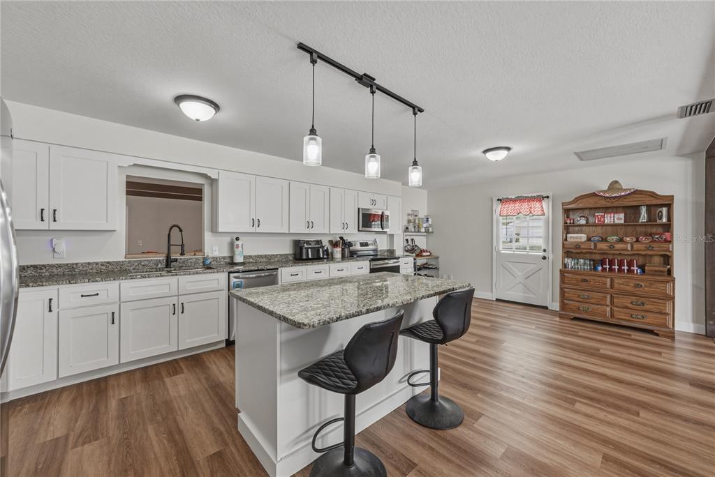 609 West Pipkin Road Lakeland, FL 33813 - Photo 3 of 72 a kitchen with stainless steel appliances granite countertop a sink and cabinets