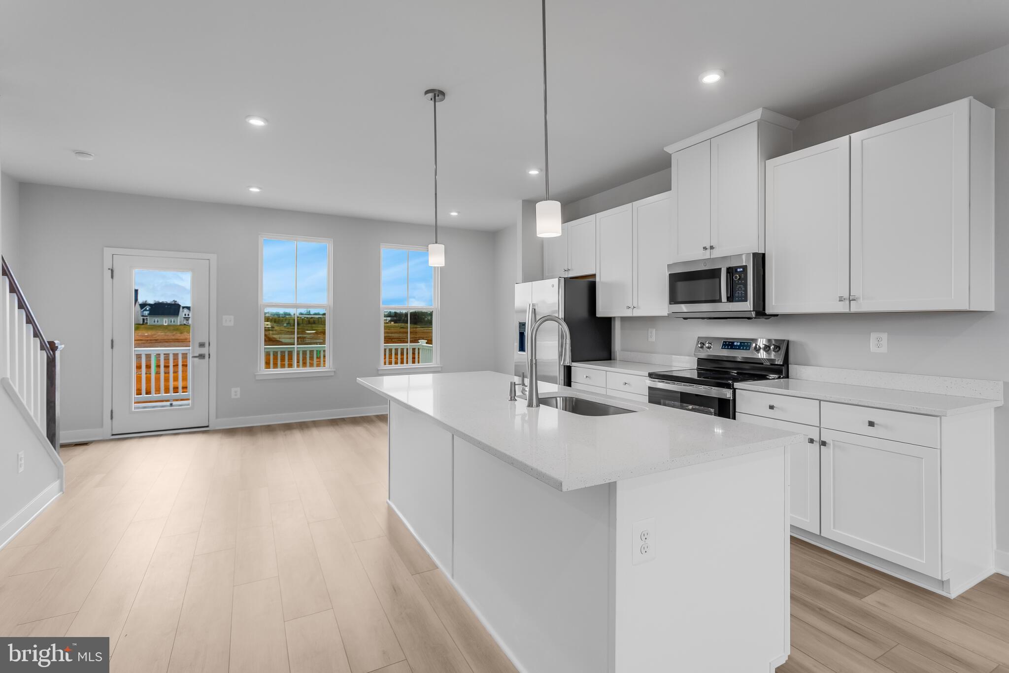 1729 Destrier Street Ranson, WV 25438 - Photo 3 of 16 a kitchen with stainless steel appliances a sink a stove a microwave a center island and cabinets