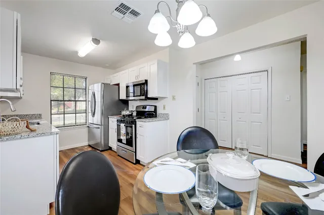 a kitchen with stainless steel appliances granite countertop a stove a sink dishwasher and cabinets with wooden floor