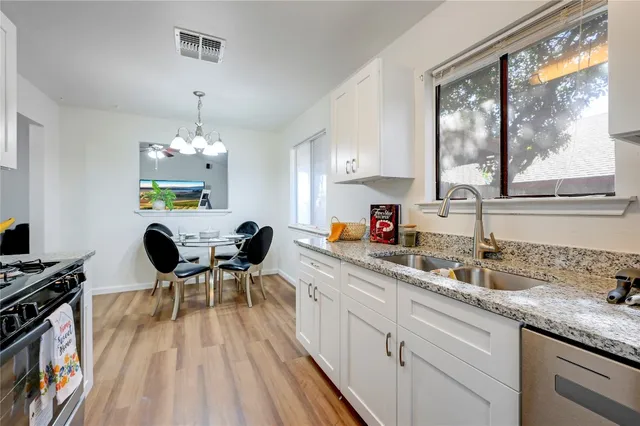 a kitchen with stainless steel appliances granite countertop a stove a sink and a microwave