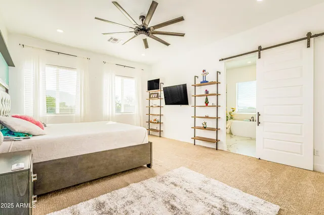 a bedroom with a bed a mirror and vanity