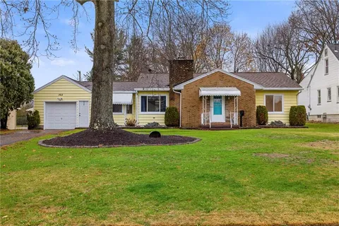 a front view of a house with a yard and trees