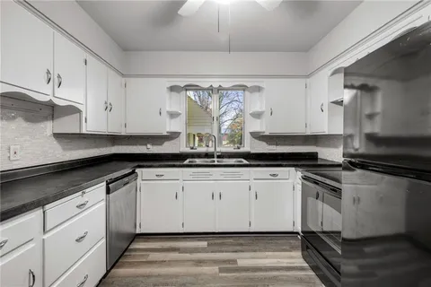 a kitchen with granite countertop white cabinets and white appliances