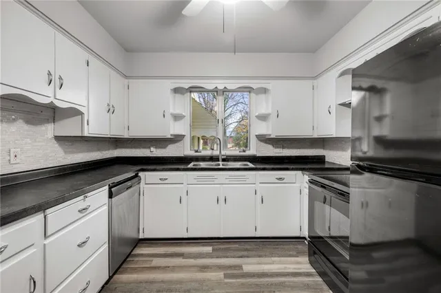 a kitchen with granite countertop white cabinets and white appliances
