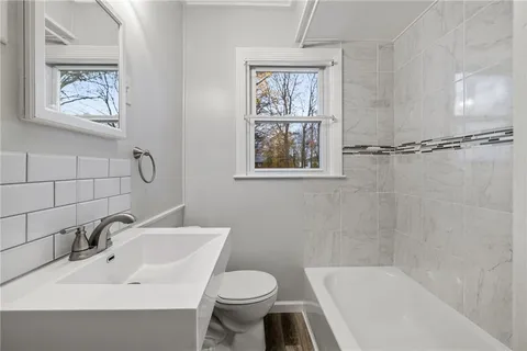 a bathroom with a sink toilet and a mirror