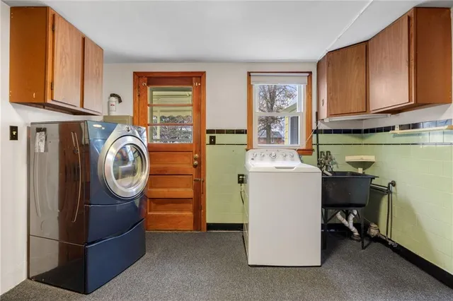 a utility room with fridge dryer and washer