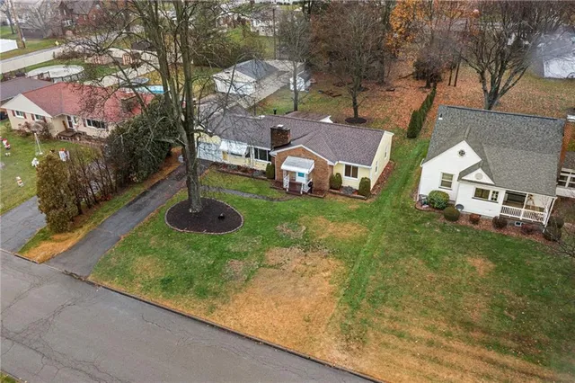 an aerial view of residential house with outdoor space and trees