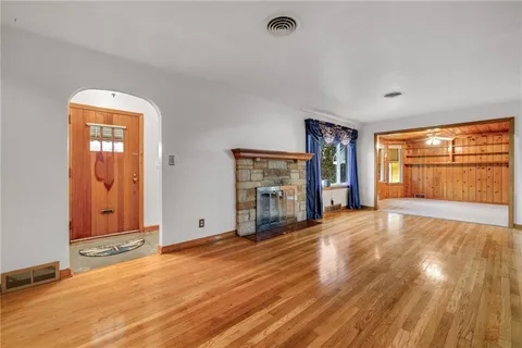 a view of an empty room with window and wooden floor