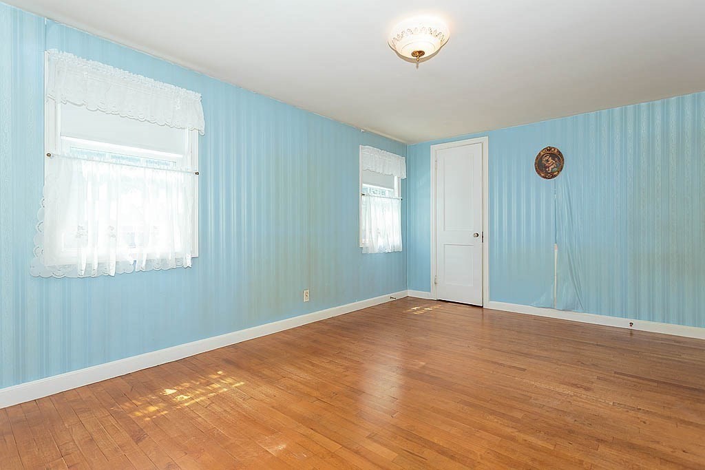 45 Magnolia Road Milton, MA 02186 - Photo 18 of 26 a view of an empty room with wooden floor and a window