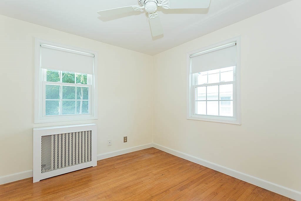 45 Magnolia Road Milton, MA 02186 - Photo 21 of 26 an empty room with wooden floor chandelier and windows