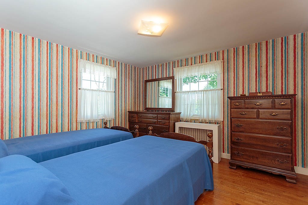 45 Magnolia Road Milton, MA 02186 - Photo 22 of 26 a bedroom with a bed and large windows