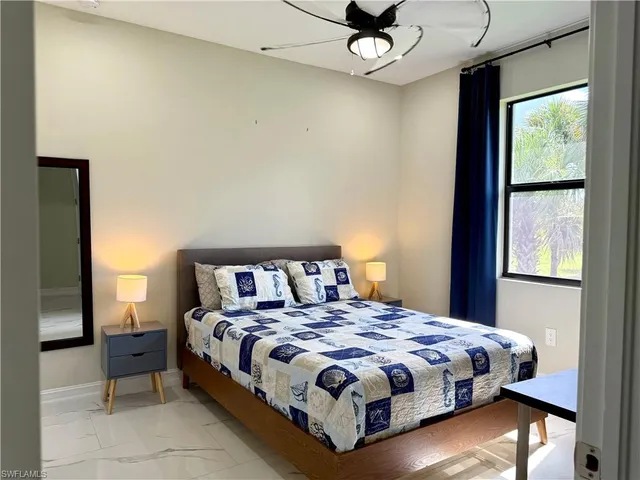 a bedroom with a large bed and a flat tv screen on dresser