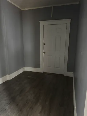 an empty room with wooden floor and closet in it