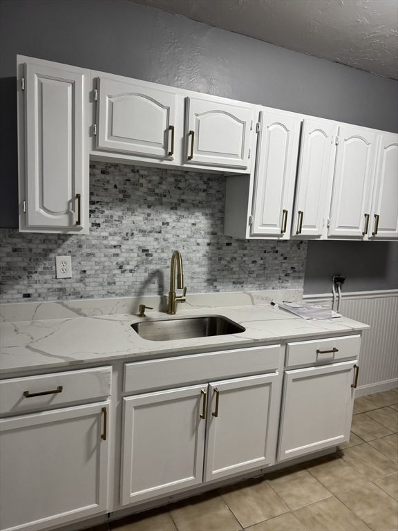 57 Hamilton Street, Unit 1 Worcester, MA 01604 - Photo 2 of 14 a kitchen with white cabinets a sink and dishwasher