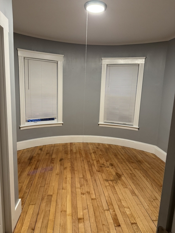 57 Hamilton Street, Unit 1 Worcester, MA 01604 - Photo 4 of 14 a view of an empty room with wooden floor and a window