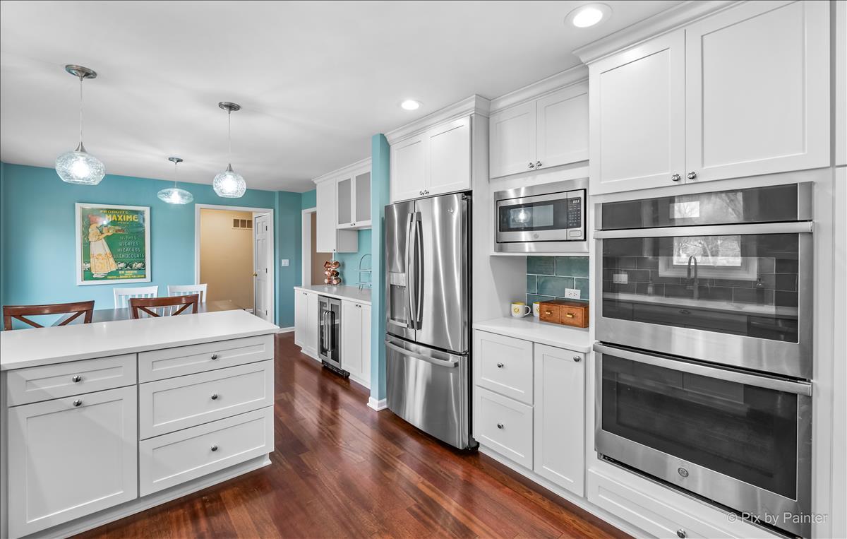 254 Perth Road Cary, IL 60013 - Photo 11 of 36 a kitchen with stainless steel appliances white cabinets and wooden floors