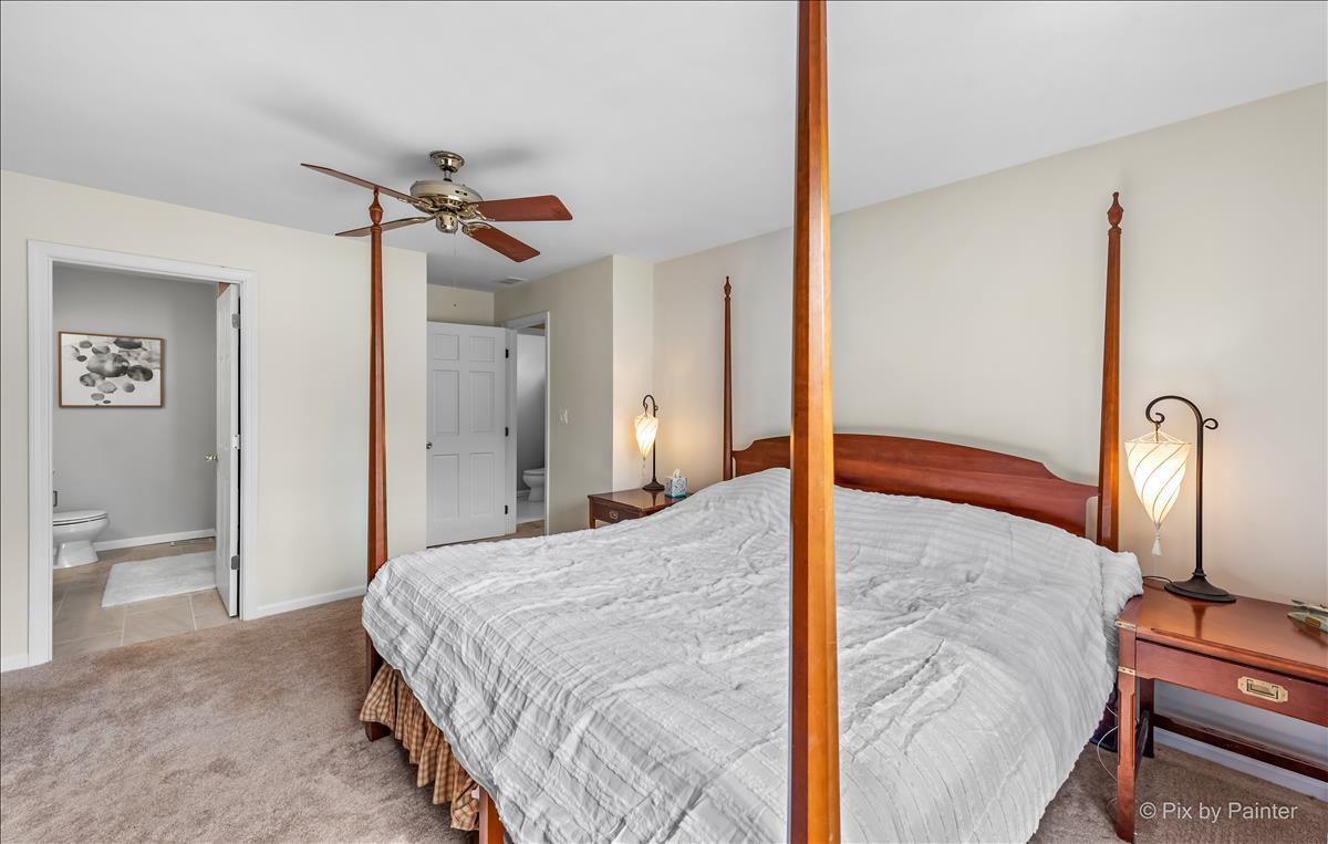254 Perth Road Cary, IL 60013 - Photo 17 of 36 a bedroom with a bed and a chandelier